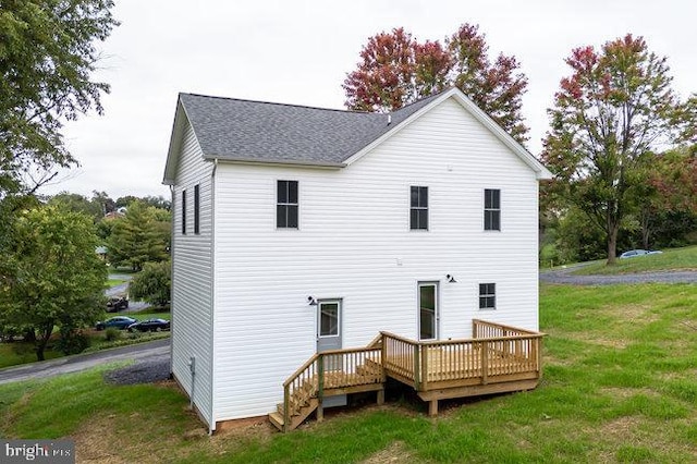 rear view of house with a deck and a yard