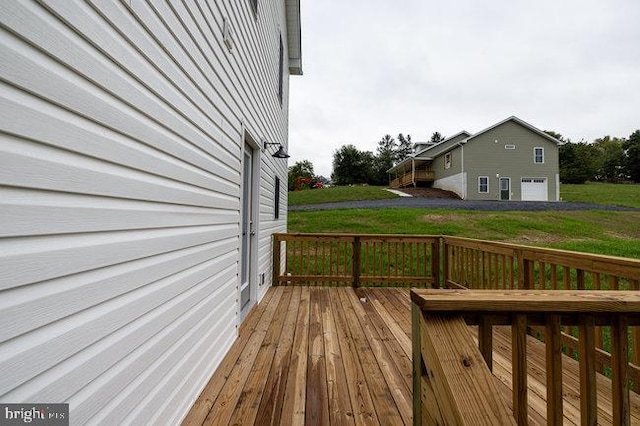 deck with a garage and a lawn