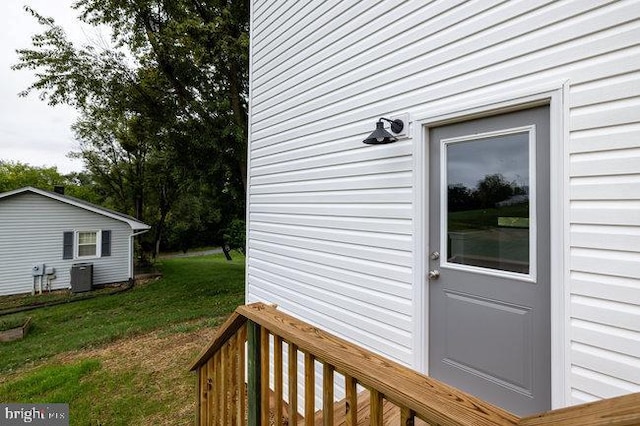 deck featuring a lawn and cooling unit