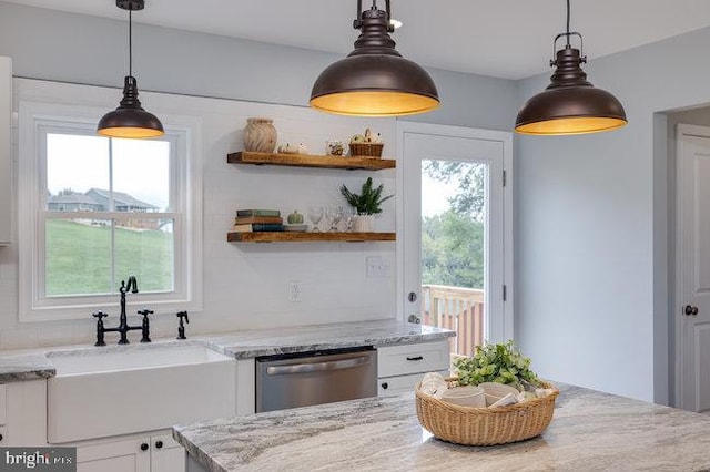 kitchen featuring dishwasher, pendant lighting, and white cabinets