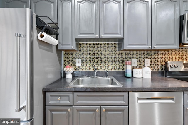 kitchen featuring gray cabinetry, sink, stainless steel appliances, and tasteful backsplash