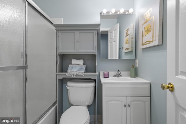 full bathroom featuring enclosed tub / shower combo, vanity, and toilet