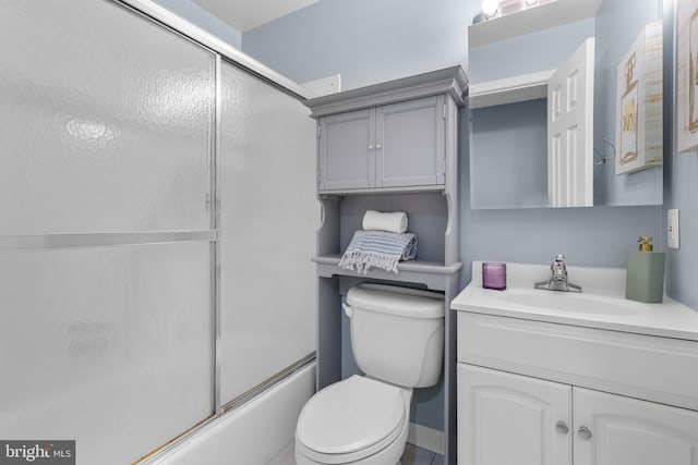 full bathroom featuring combined bath / shower with glass door, vanity, and toilet