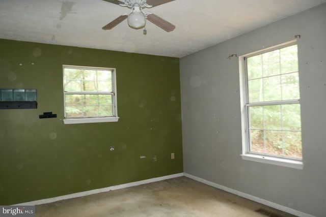 spare room featuring ceiling fan and plenty of natural light