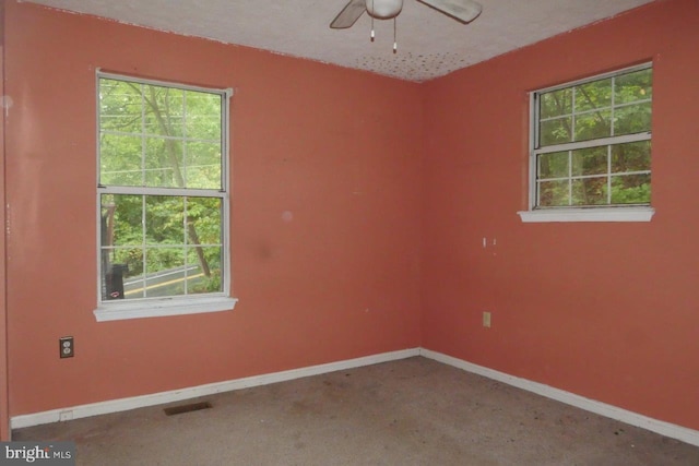 empty room featuring ceiling fan, a textured ceiling, and carpet flooring