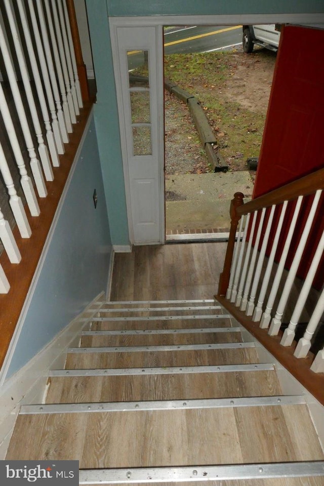 staircase with hardwood / wood-style floors