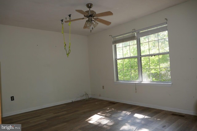 empty room with ceiling fan and dark hardwood / wood-style flooring