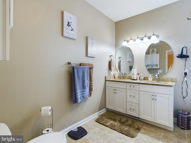 bathroom with tile patterned flooring, vanity, and toilet