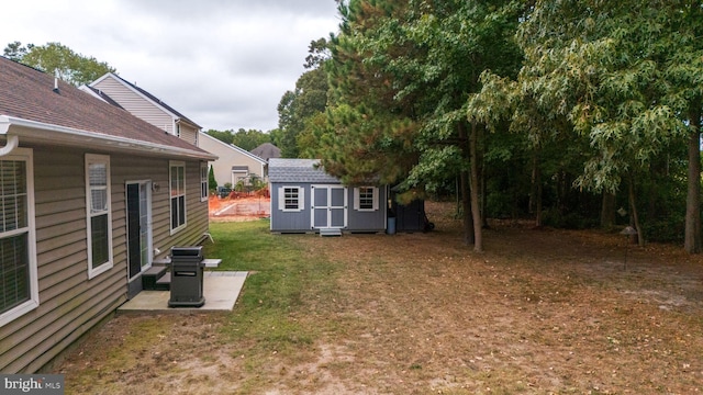 view of yard with a storage unit and a patio area