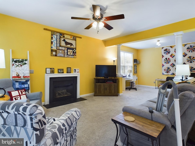 carpeted living room with decorative columns and ceiling fan