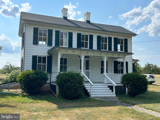 view of front of house with a porch and a front yard