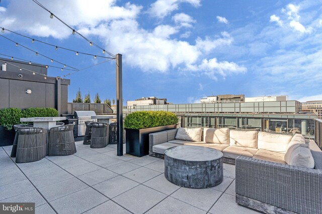 view of patio with grilling area and an outdoor living space with a fire pit