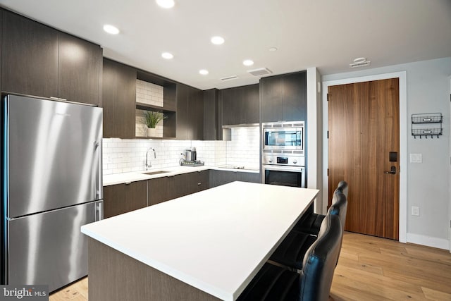 kitchen featuring light hardwood / wood-style flooring, stainless steel appliances, and a center island