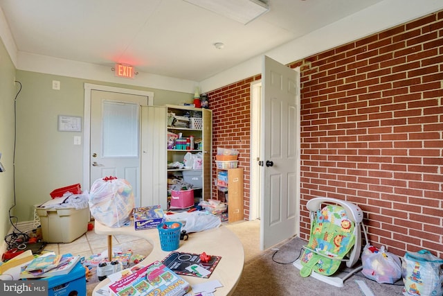 rec room with brick wall and carpet floors