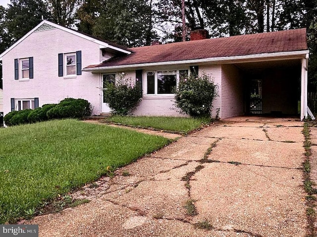 split level home with a front lawn and a carport