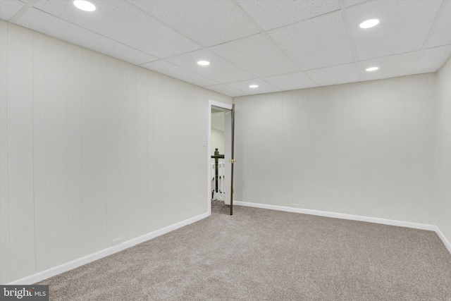 spare room with a drop ceiling and carpet flooring