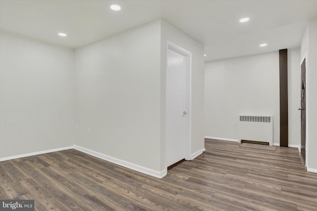 spare room with radiator and dark hardwood / wood-style flooring