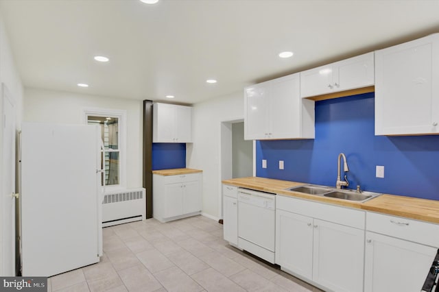 kitchen with radiator, sink, white appliances, white cabinetry, and wood counters