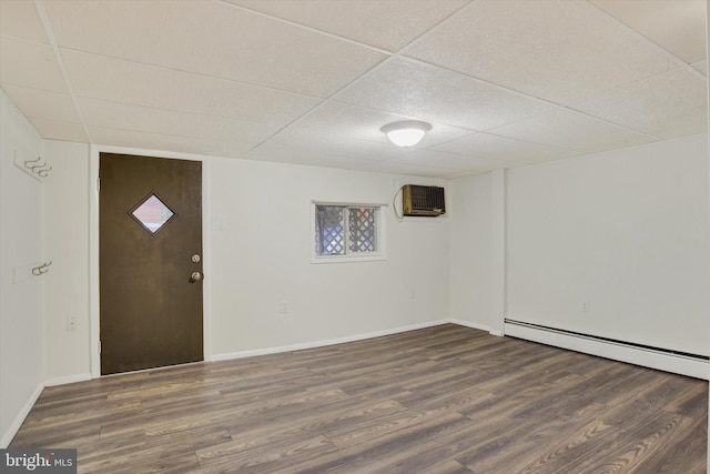 entrance foyer featuring a wall unit AC, a baseboard radiator, dark hardwood / wood-style floors, and a paneled ceiling