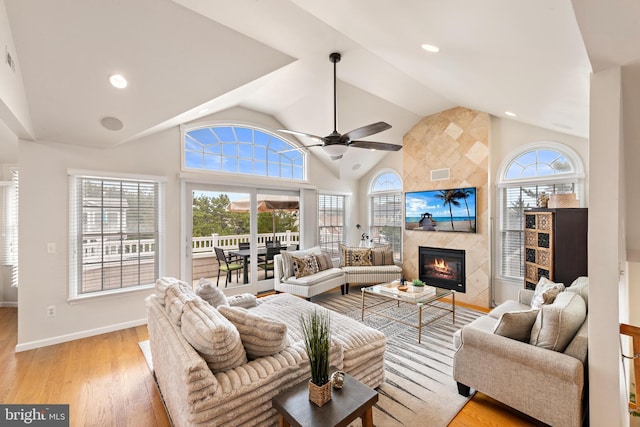 living room with ceiling fan, light hardwood / wood-style flooring, a fireplace, and a wealth of natural light