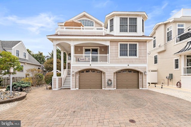 view of front of property featuring a balcony and a garage