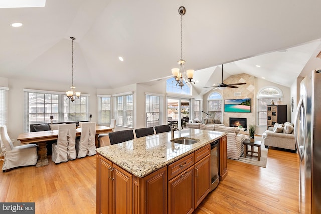 kitchen with ceiling fan with notable chandelier, light hardwood / wood-style flooring, a healthy amount of sunlight, and stainless steel fridge