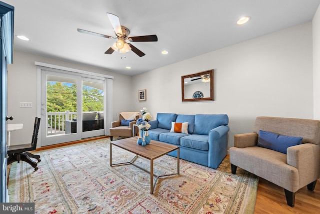 living room with light wood-type flooring and ceiling fan