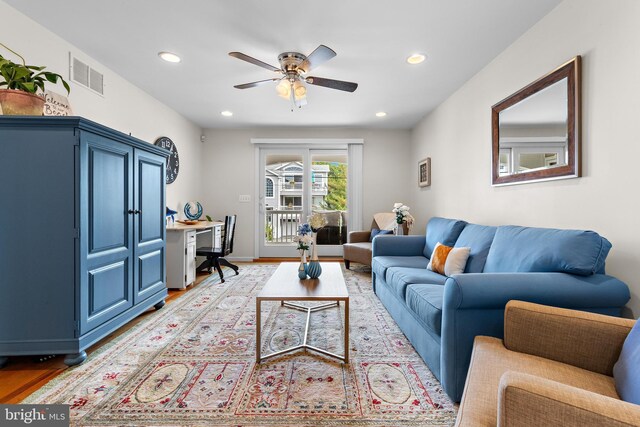 living room featuring light wood-type flooring and ceiling fan