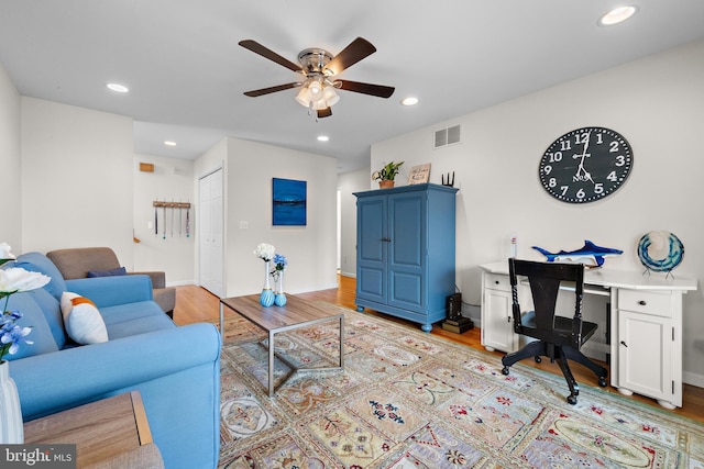 living room with light wood-type flooring and ceiling fan