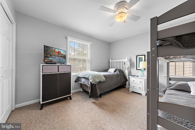 carpeted bedroom with ceiling fan and a closet