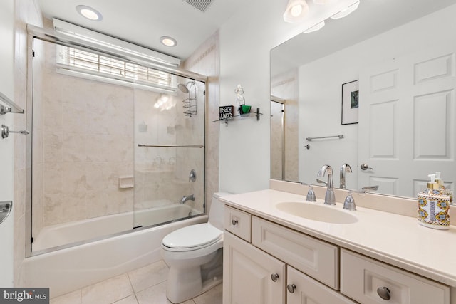 full bathroom with tile patterned floors, enclosed tub / shower combo, vanity, and toilet