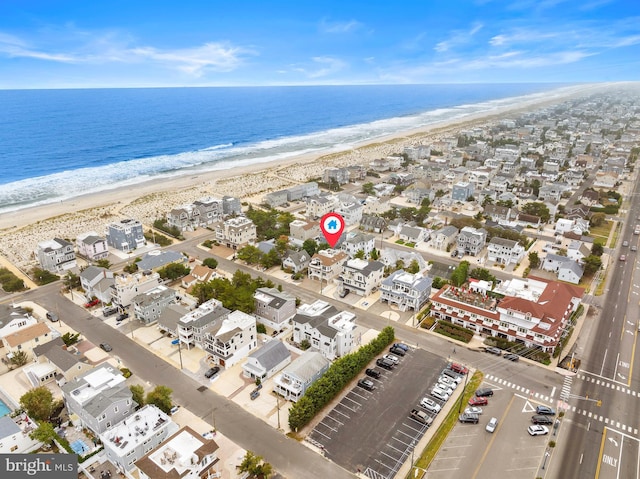 bird's eye view featuring a water view and a beach view