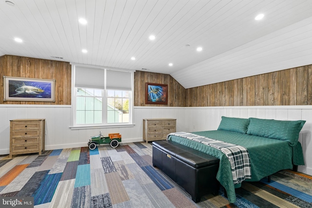 bedroom with wood walls and vaulted ceiling