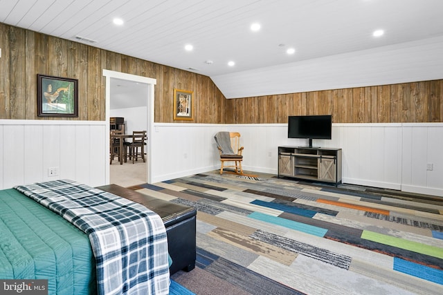 carpeted living room featuring lofted ceiling and wooden walls