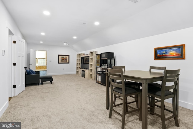 carpeted dining room featuring lofted ceiling