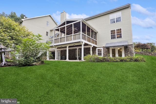 back of property featuring a yard and a sunroom