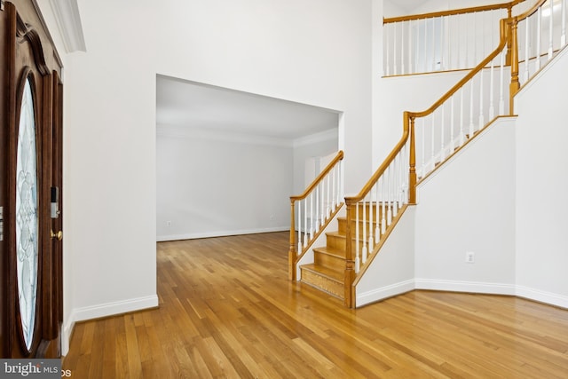 entryway with crown molding and hardwood / wood-style floors