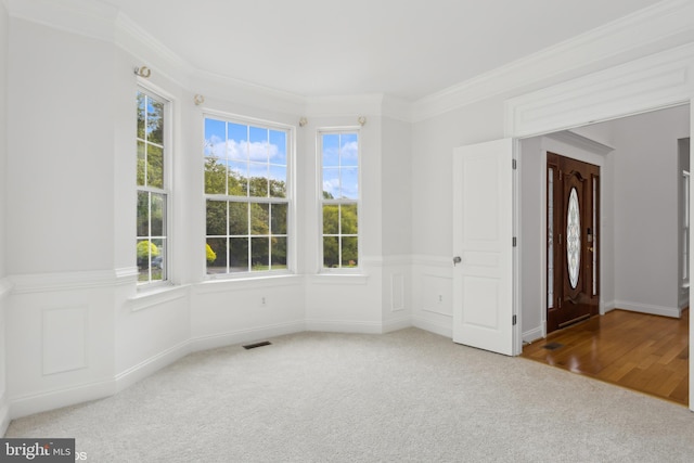 carpeted empty room with ornamental molding and visible vents