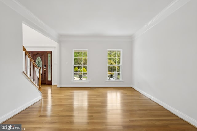 interior space with light wood-style flooring, ornamental molding, baseboards, and stairs
