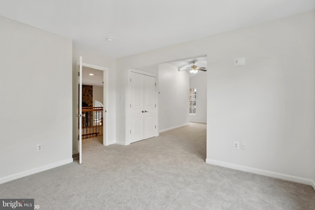 spare room featuring light carpet and ceiling fan