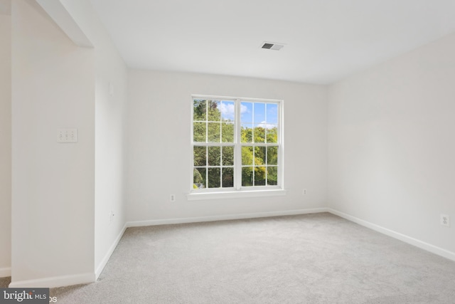 carpeted spare room with baseboards and visible vents