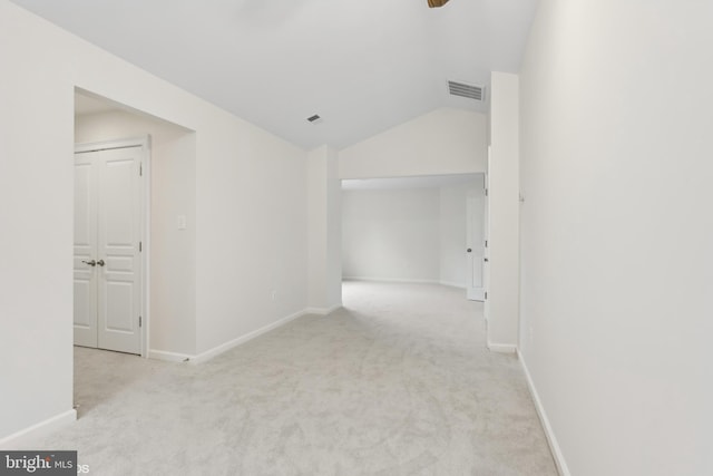 corridor with light carpet and vaulted ceiling