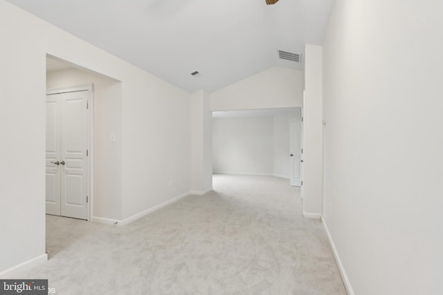 unfurnished room featuring baseboards, carpet, lofted ceiling, and visible vents