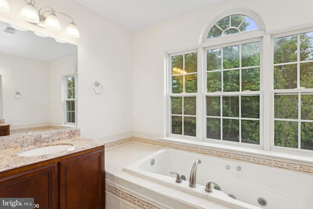 bathroom featuring vanity and a relaxing tiled tub