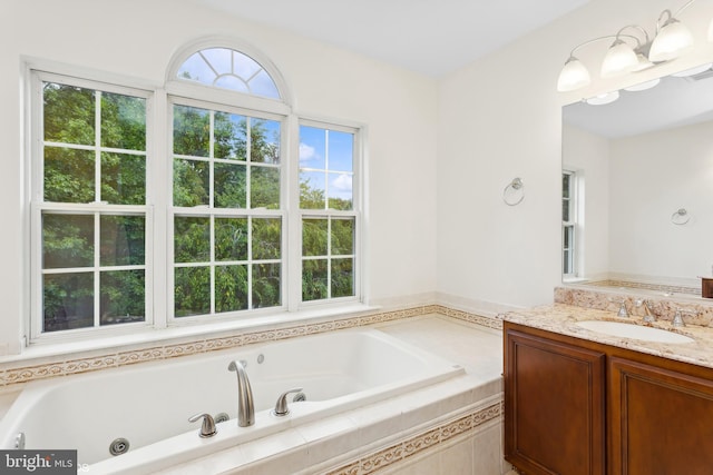 bathroom with vanity and tiled bath