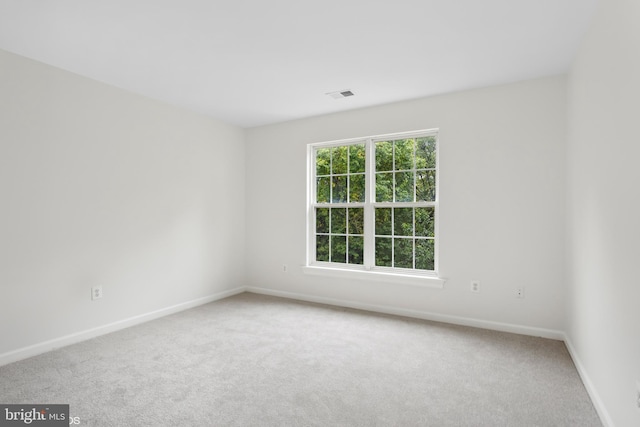 empty room featuring baseboards, carpet floors, and visible vents