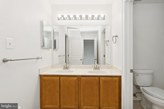 bathroom with tile patterned flooring, vanity, and toilet