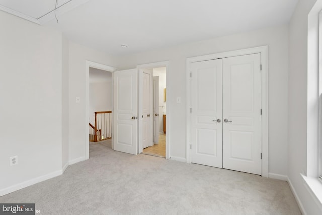 unfurnished bedroom featuring a closet and light colored carpet