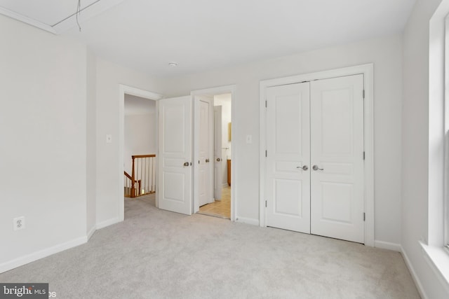 unfurnished bedroom with a closet, carpet flooring, and baseboards