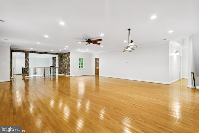 unfurnished living room featuring light hardwood / wood-style floors, ornamental molding, and ceiling fan